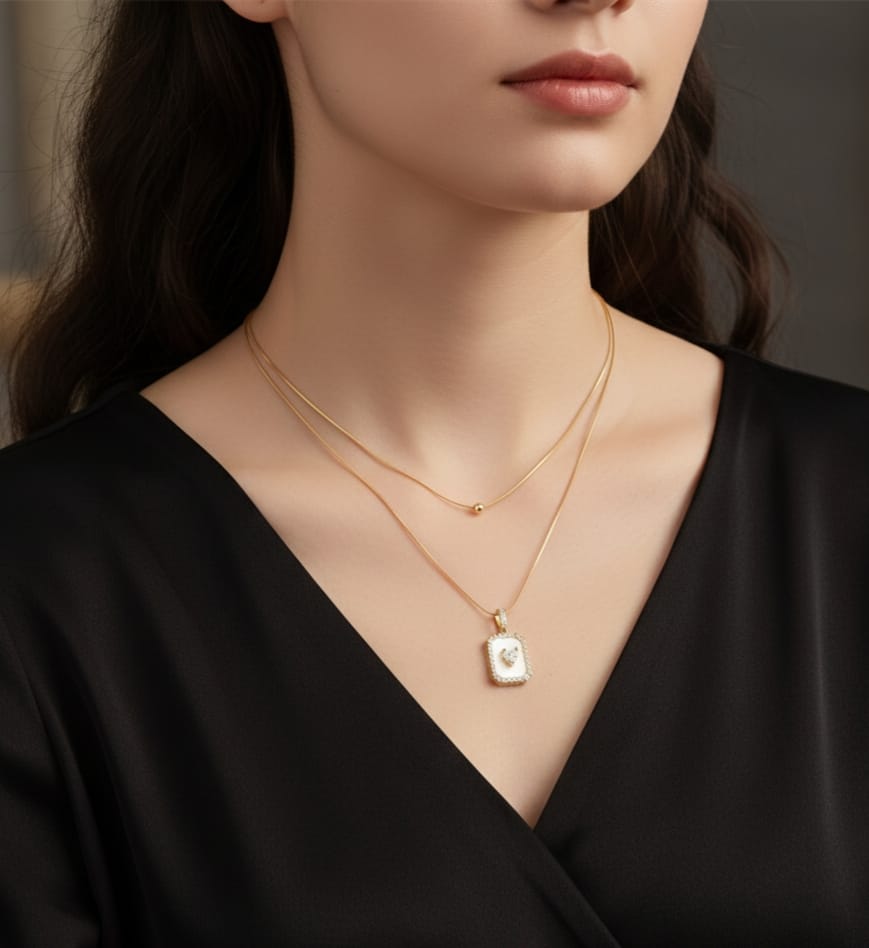 Gold double-layered  chain necklace with a bead and a white mother-of-pearl square pendant with a center heart HJ73