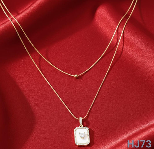 Gold double-layered  chain necklace with a bead and a white mother-of-pearl square pendant with a center heart HJ73