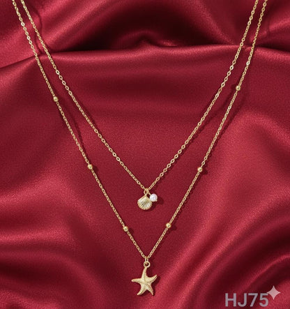Gold double-layered necklace with satellite chain, featuring a seashell/pearl drop and a textured starfish pendant HJ75