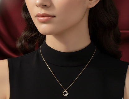 Delicate gold chain necklace with a small circular pendant framing a sparkling gem and a white cloud charm HJ76
