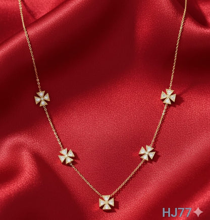 Gold station necklace with five evenly-spaced, diamond-studded, four-petal flower or cross-shaped motifs HJ77